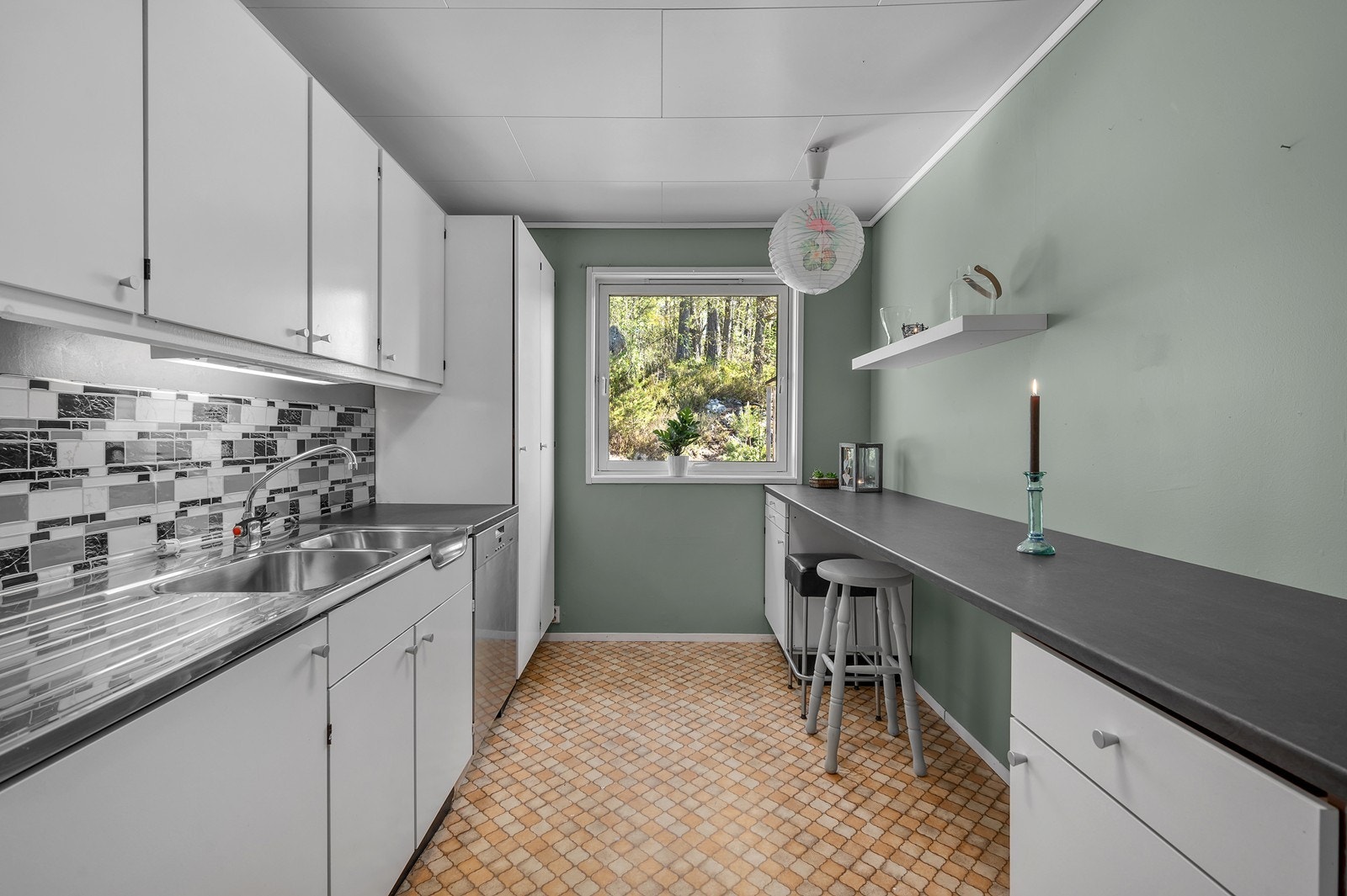 Kjøkkeninnredning med slette fronter, stålvask og laminert benkeplate. Galleribilde