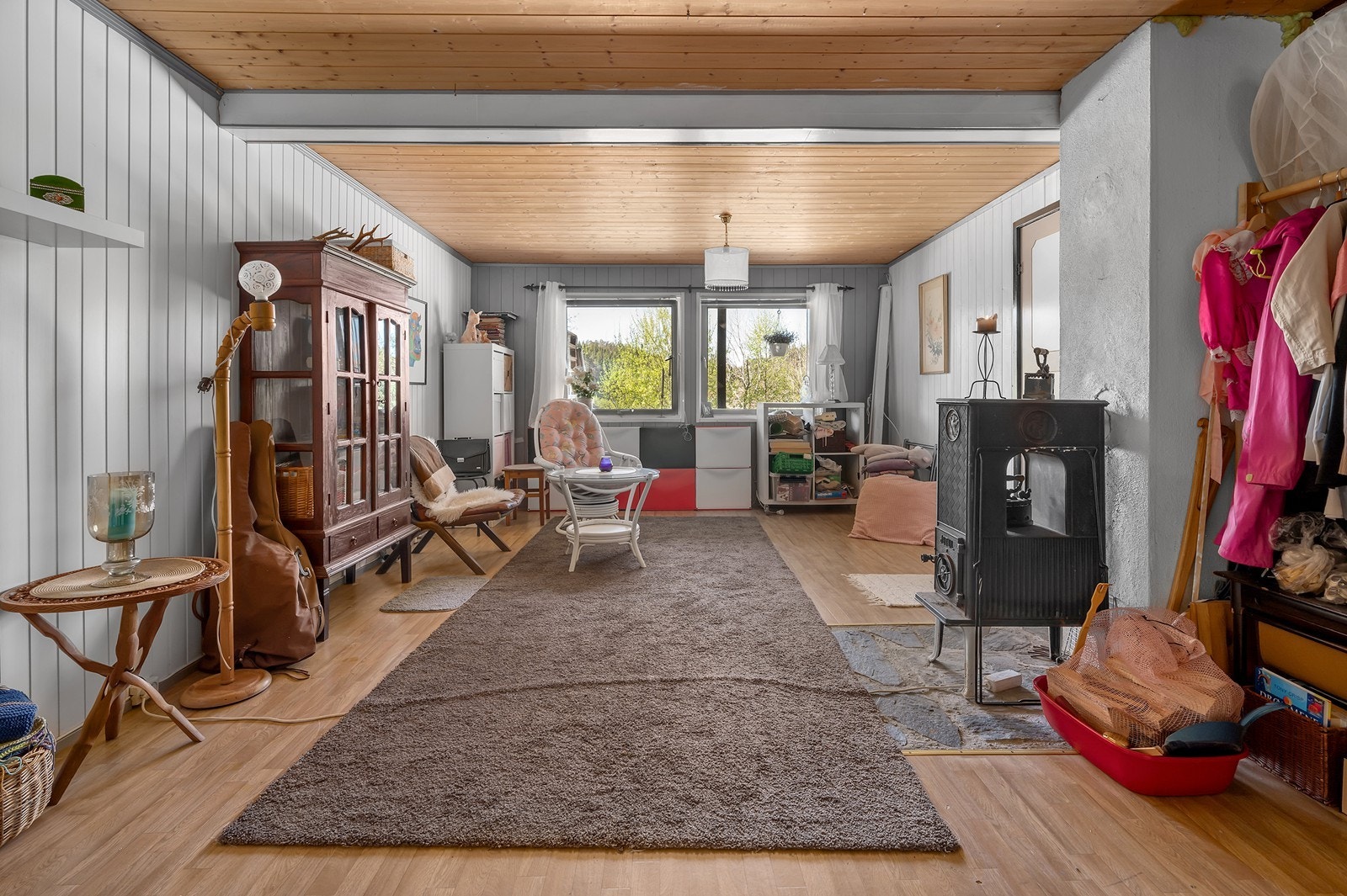 Romslig innredet rom med vedfyrt ovn. Galleribilde