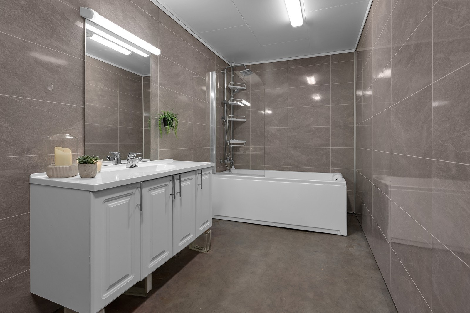 Flott fargevalg. Baderomsplater på vegger og takplater i himling. Toalett, baderomsinnredning og badekar. Galleribilde