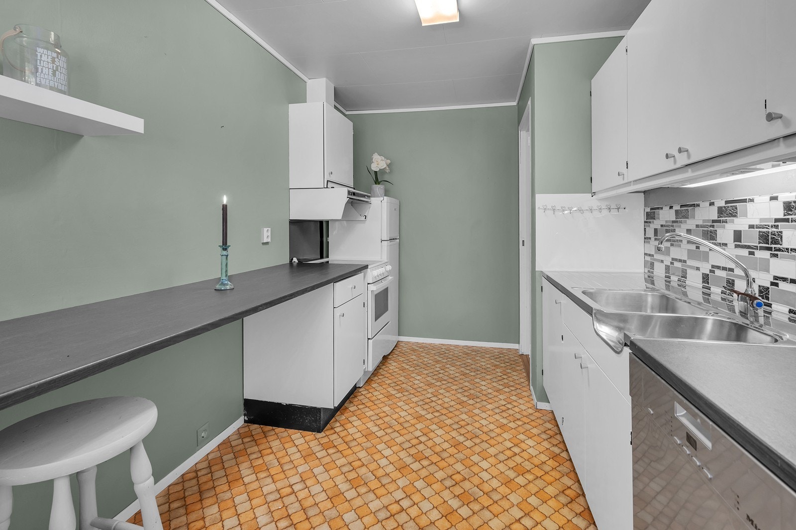 Komfyr, kjøleskap og oppvaskmaskin. Ventilator har avtrekk. Galleribilde