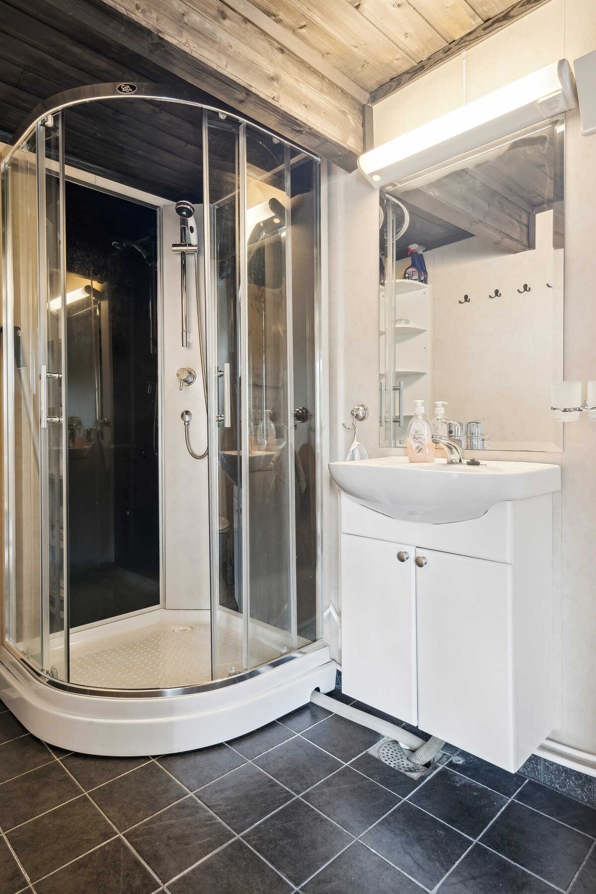 Badet har vegghengt servantinnredning med speil og overlys. Galleribilde