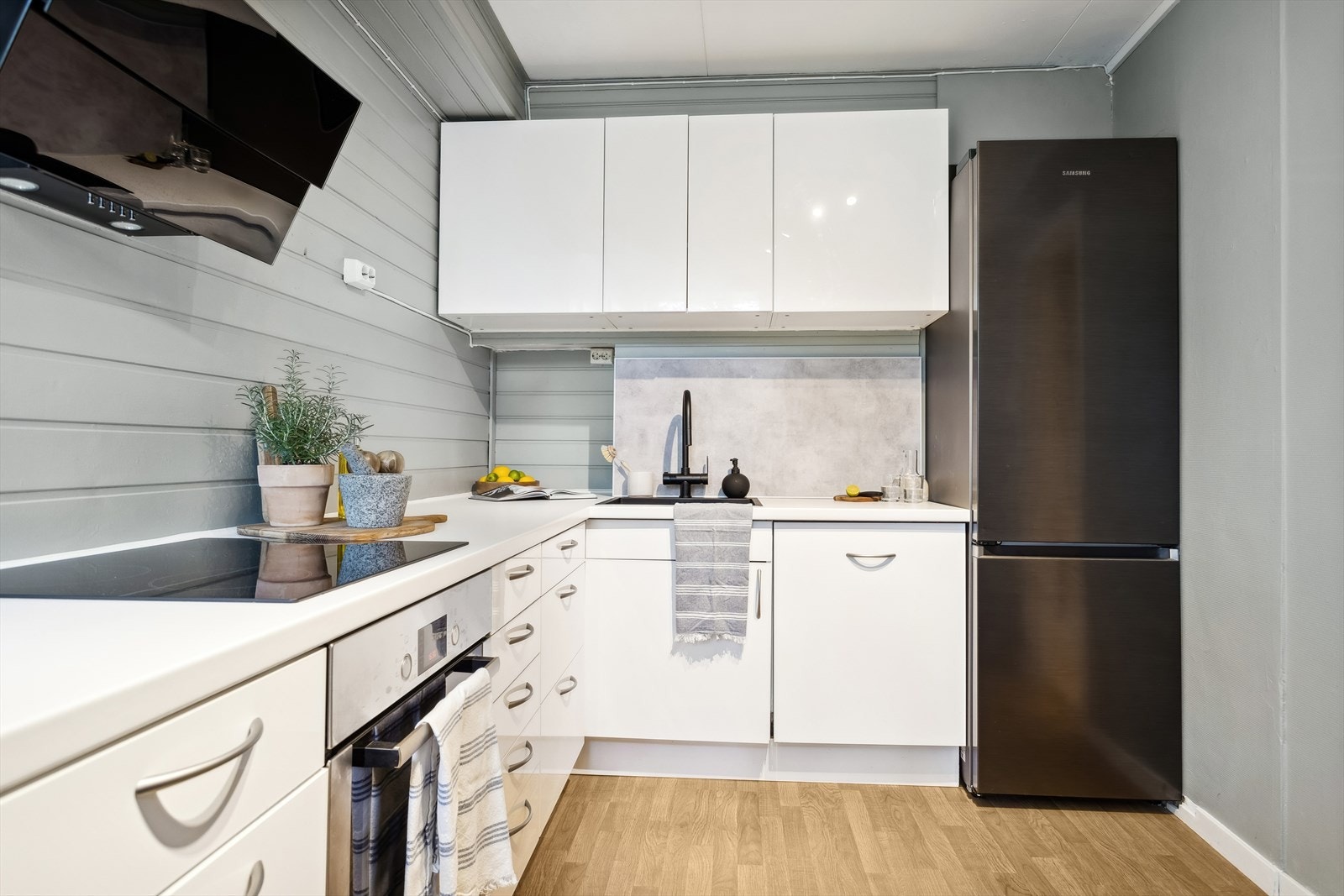 Kjøkkenet er ca 8,6 m² og har innredning fra 2011 som består av over- og underskap med folierte fronter og skrog. Laminat benkeplate med nedsenket oppvaskkum og platetopp. Galleribilde
