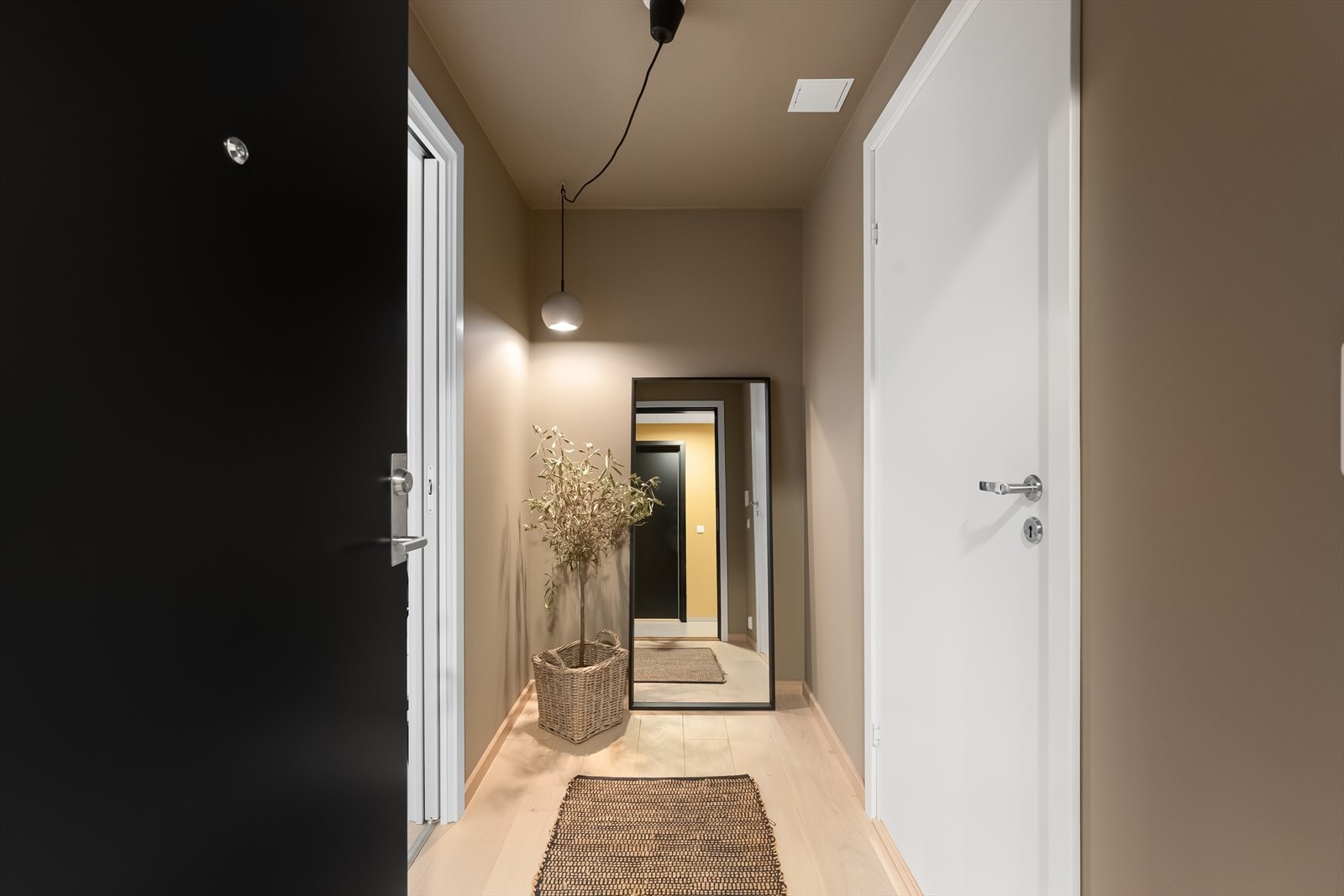 Trivelig gang i en mørkere fargetone for gode kontraster med resten av leiligheten. Galleribilde