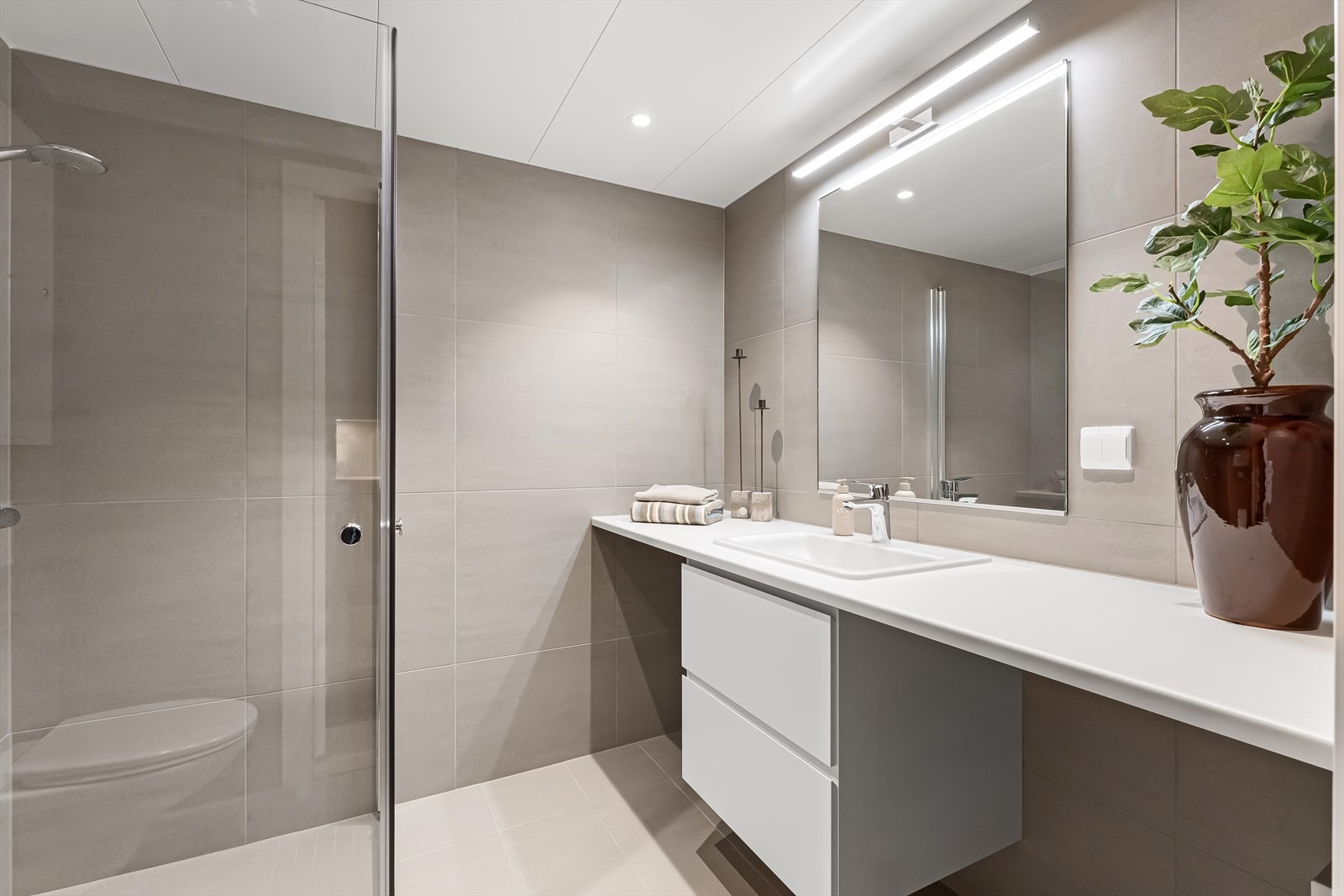 Badet er moderne med spotter i himling og lys over speil. Galleribilde