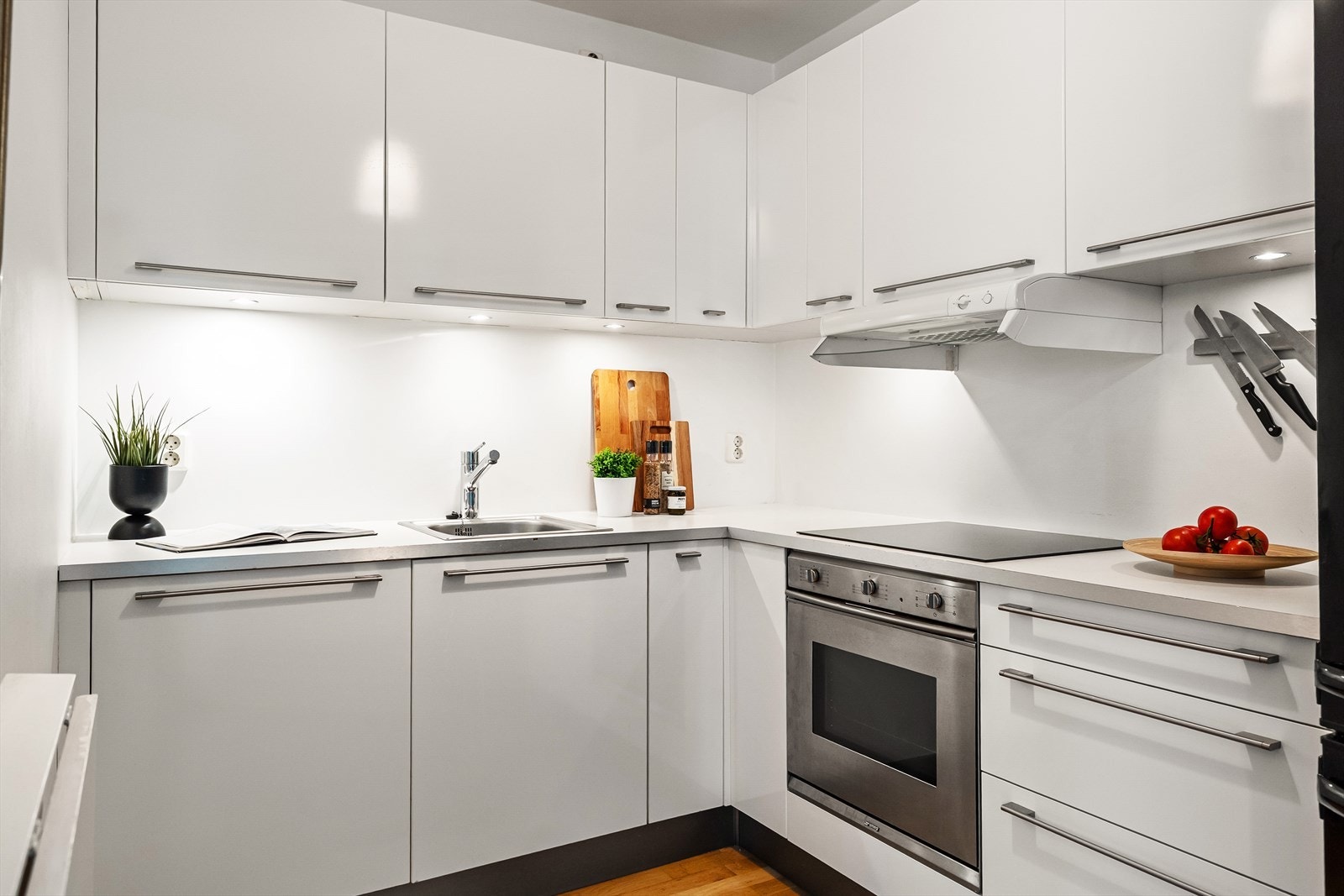 Stilrent kjøkken med glatte laminerte fronter og laminert benkeplate med nedsenket oppvaskkum som har etgreps blandebatteri. Galleribilde