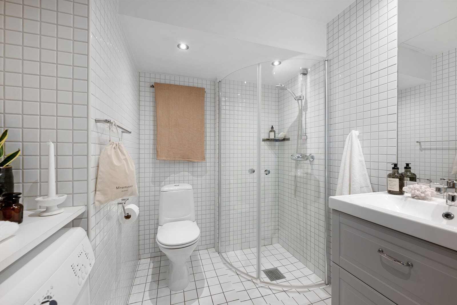 Bad innredet med toalett, dusjhjørne med vegger/dører i herdet glass, servantinnredning og innfelt speil Galleribilde