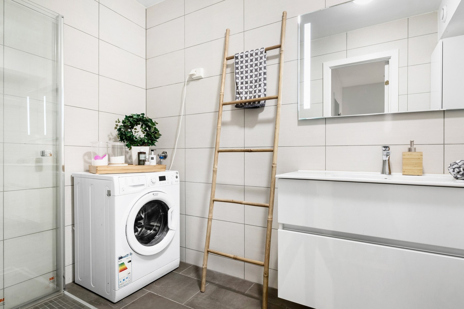 Opplegg for vaskemaskin på badet. Det er foldedører i dusjen som gjør at de kan settes helt inn til veggen. Galleribilde