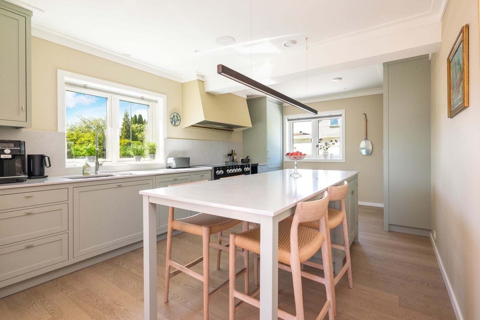 Innredningen har slette fronter, benkeplate - og beskyttelsesplater av kompositt over kjøkkenbenk. Galleribilde