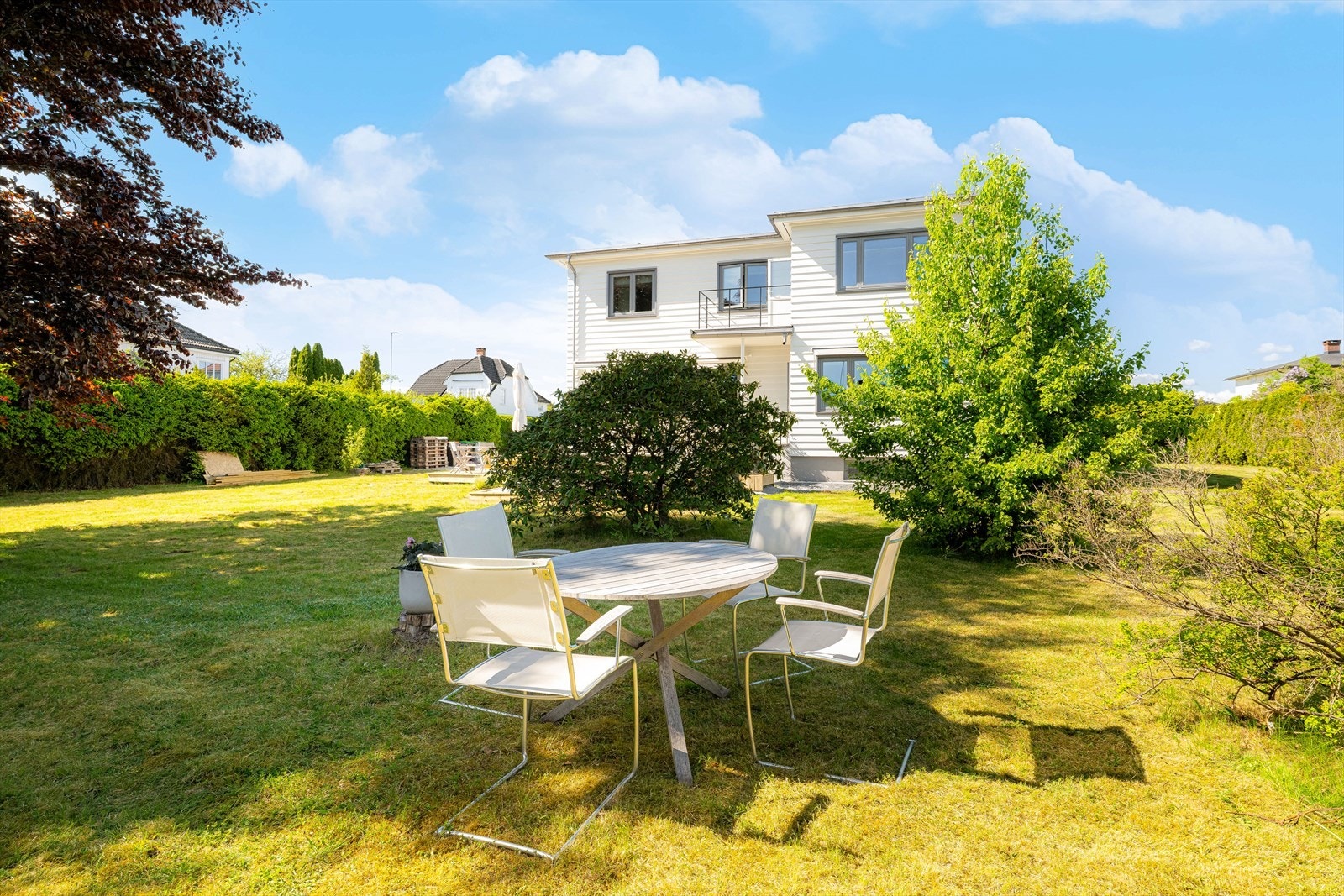 Hagen fremstår idyllisk og fin - beplantet med diverse trær og busker. Galleribilde