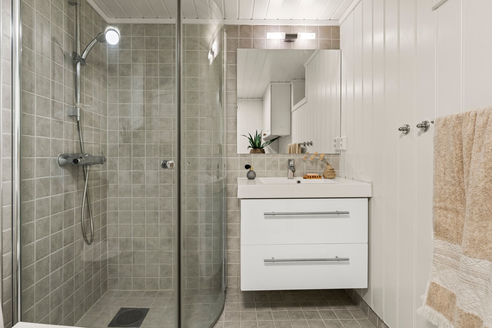 Det er dusjkabinett og servant med underskap, speilskap og toalett på badet. Videre er det elektrisk veggvifte. ((ikke søkt om bruksendring til bad) Galleribilde