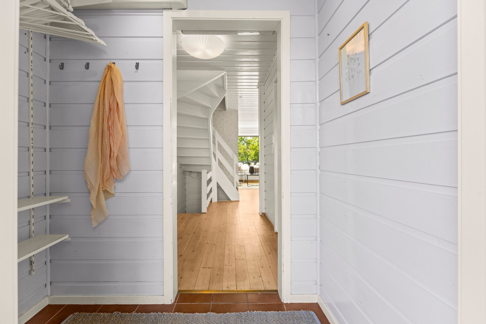 Inn i entreen er det god plass, med garderobeløsning og fliser på gulv. Galleribilde