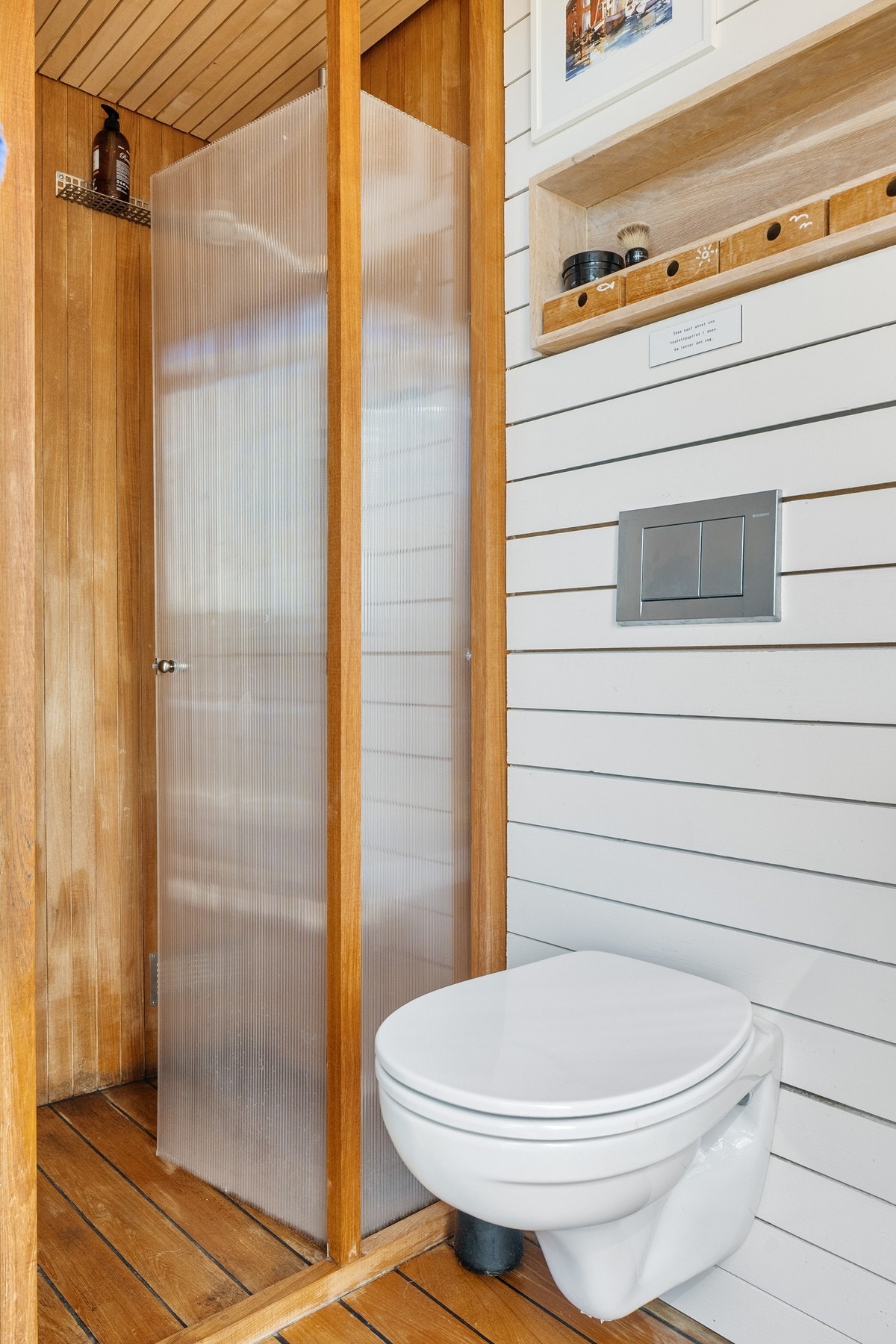 Badet er innredet med servant, dusj, toalett, opplegg for vaskemaskin og gassdrevet varmtvannsbereder Galleribilde