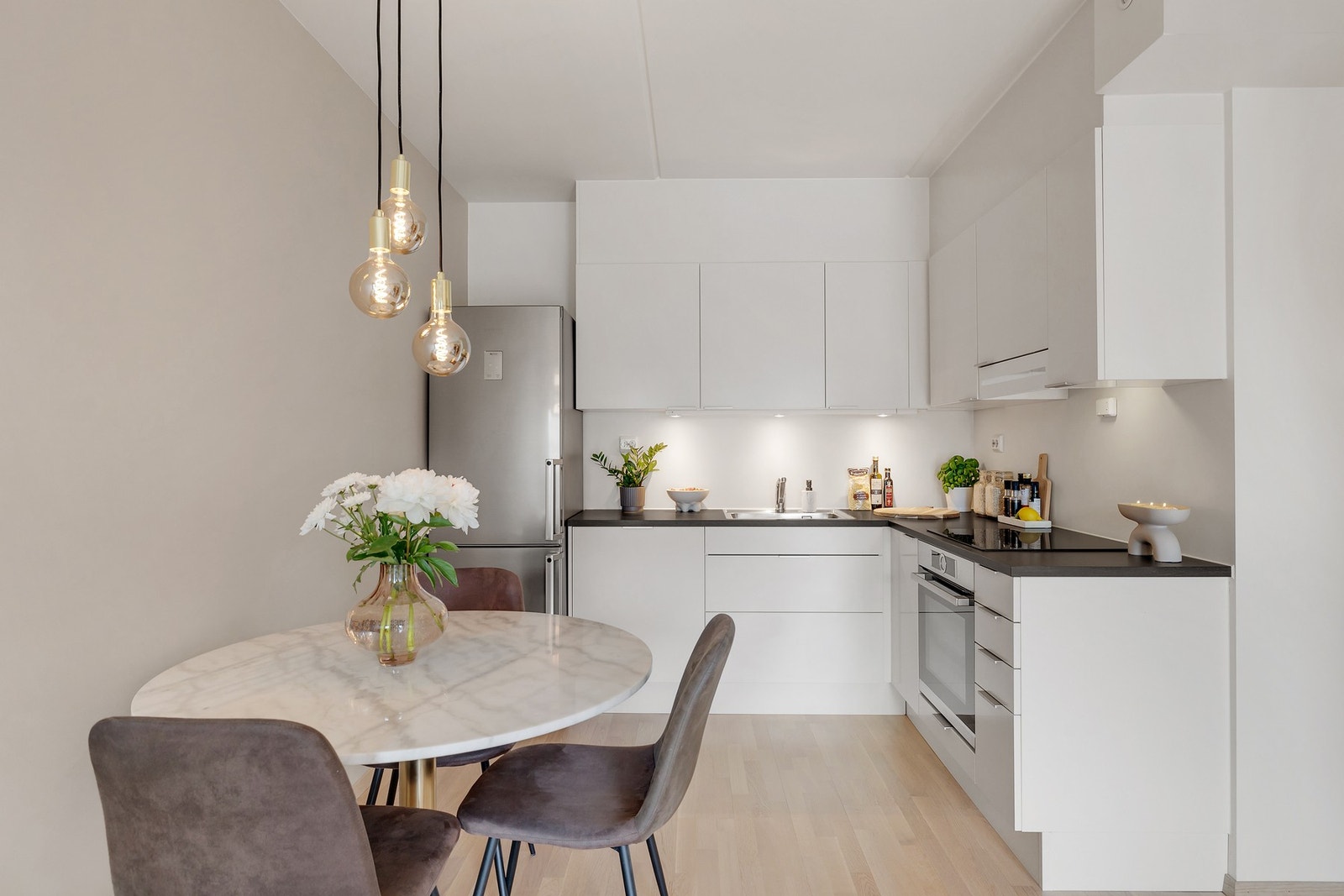 Moderne og stilrent kjøkken i åpen løsning mot stue og spiseplass. Galleribilde