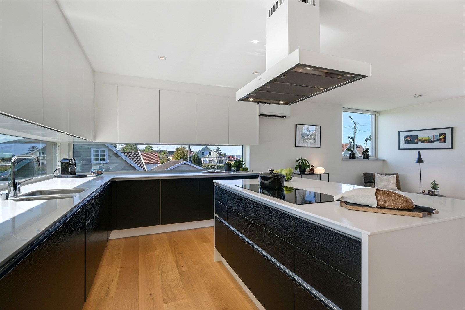 Flott åpen kjøkkenløsning med HTH innredning med corian benkeplater og integrerte Miele hvitevarer. Galleribilde