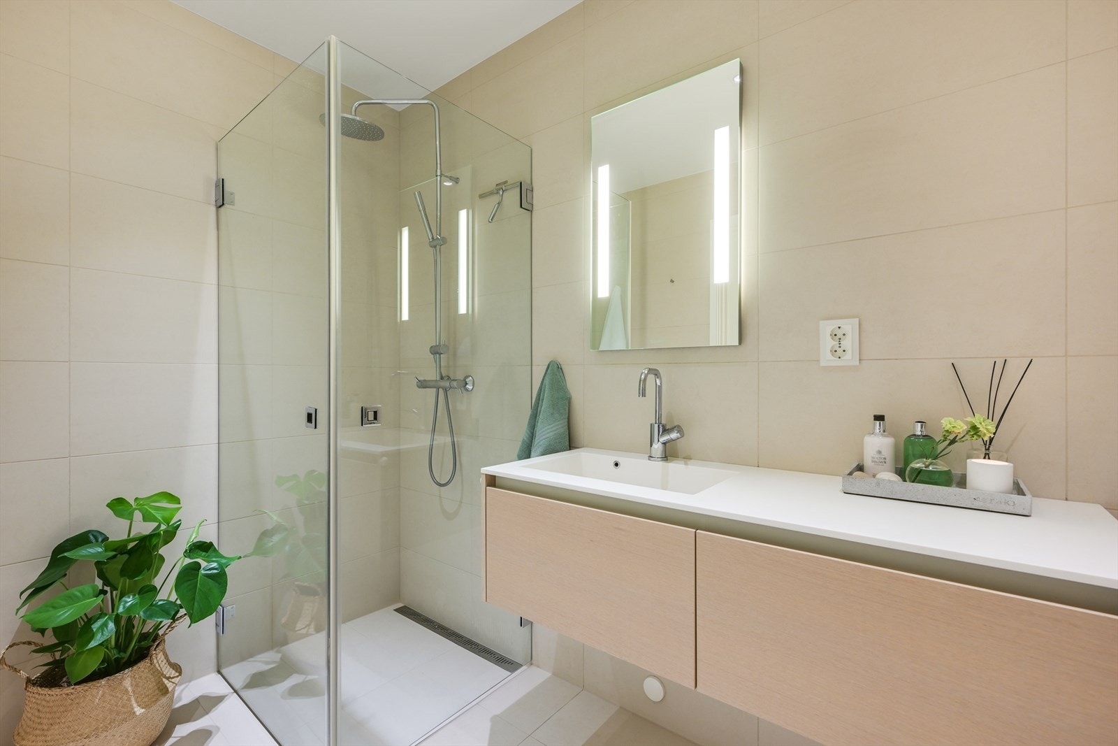 Fliselagt bad/wc med vannbåren varme, dusjhjørne, toalett og servant. Også her speil med innfelt lys. Galleribilde