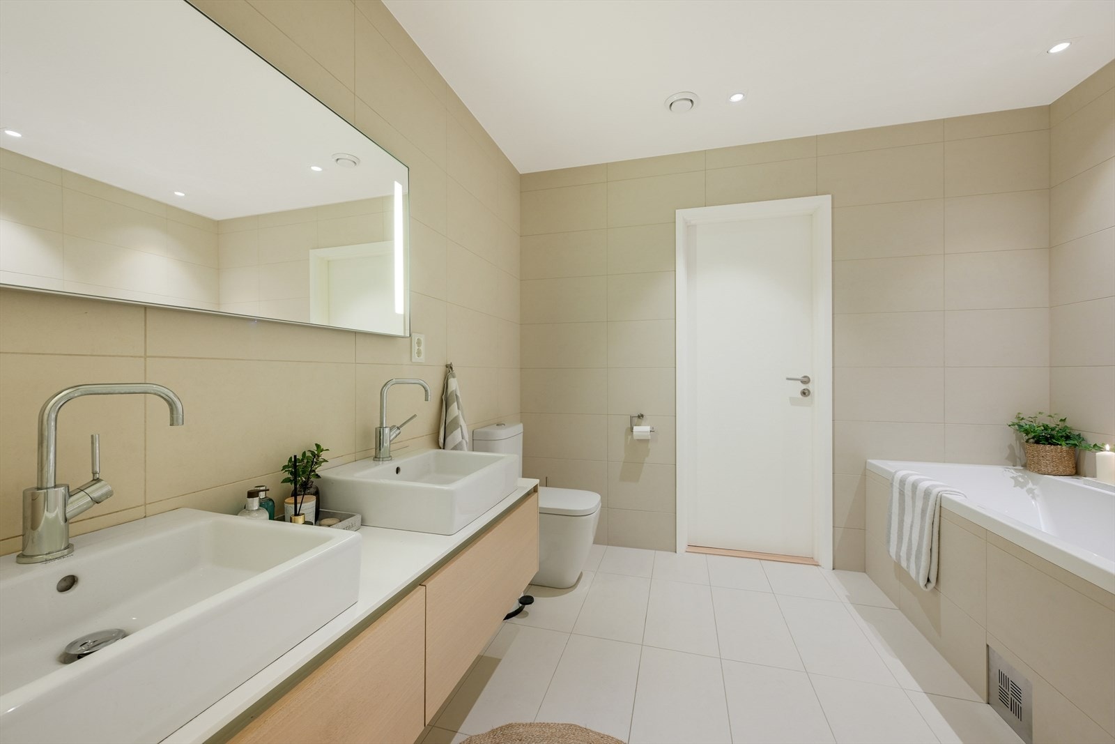 Bad/wc med toalett, badekar, dusjnisje, 2 servanter, speil med innfelt lys. Galleribilde