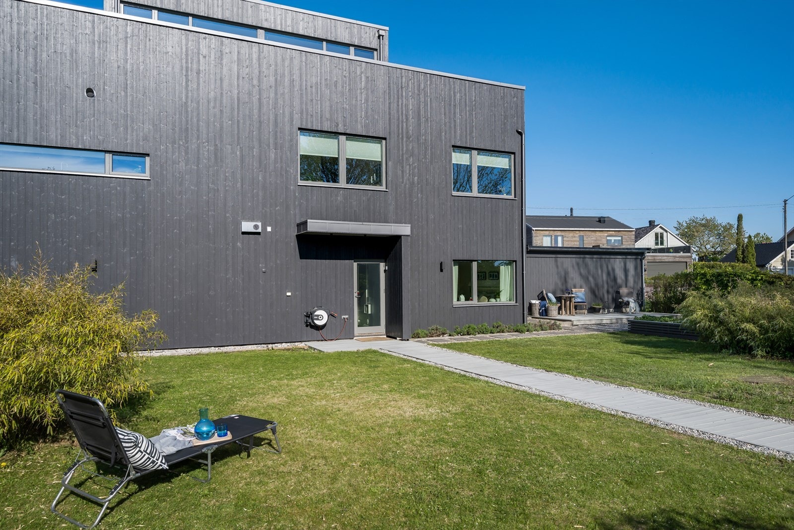 Solrik hage i bakkant av huset. Galleribilde