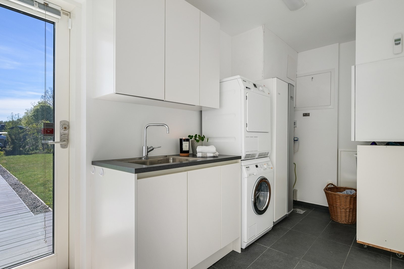 Vaskerom/teknisk rom med utgang til hage, vann til vann Nibe varmepumpe, balansert ventilasjon, begge med nylig utført service. Innredning med servant. Galleribilde