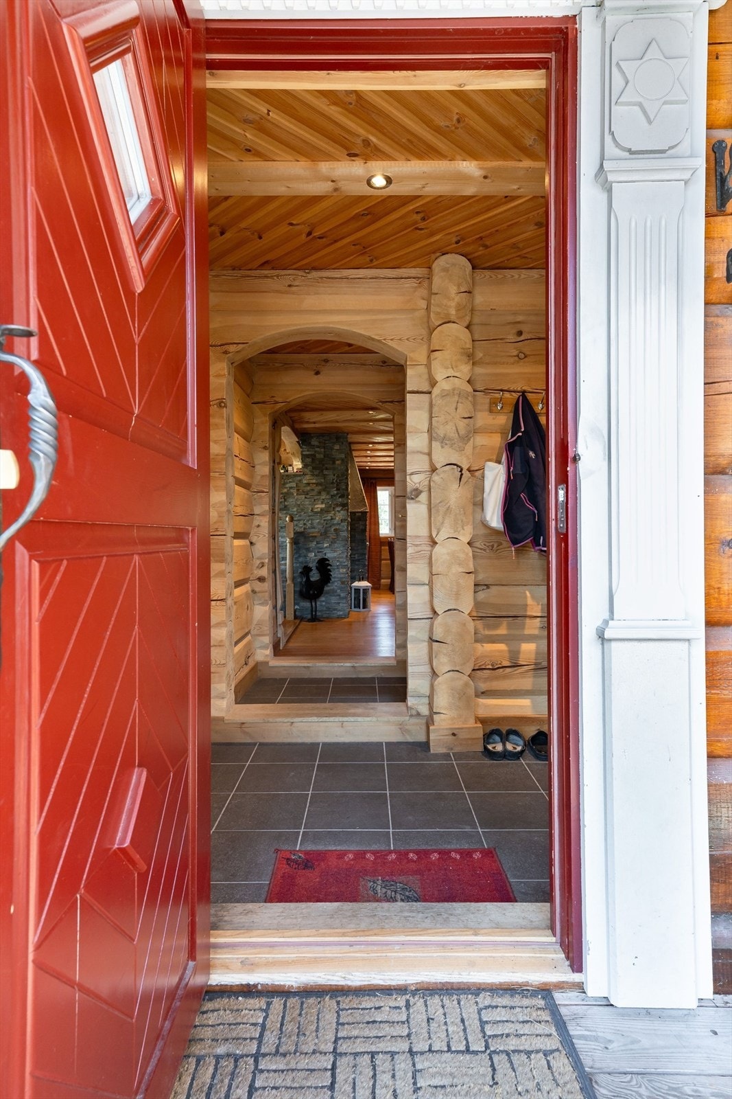 Overbygget inngangsparti med utskårne søyler rundt inngangsdør. Galleribilde