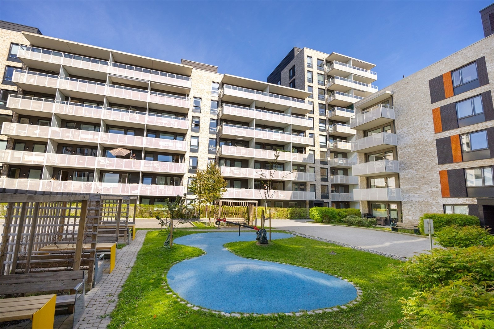 Fasadebilde av blokken og nærområdet inne på Grefsen Stasjonsby. Her kan barna leke fritt, og man kan hygge seg på områdets fellesbenker.
Denne leiligheten disponerer en romslig kjellerbod på hele 9 m² med takhøyde på 2,6 m, merket med H0103. Galleribilde