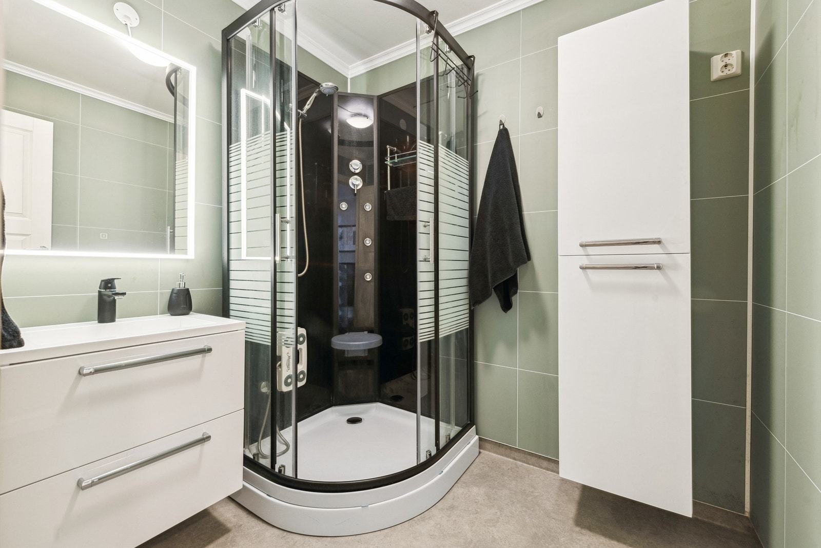 Badet har innredning med nedfelt servant og dusjkabinett samt elektrisk styrt vifte. Galleribilde