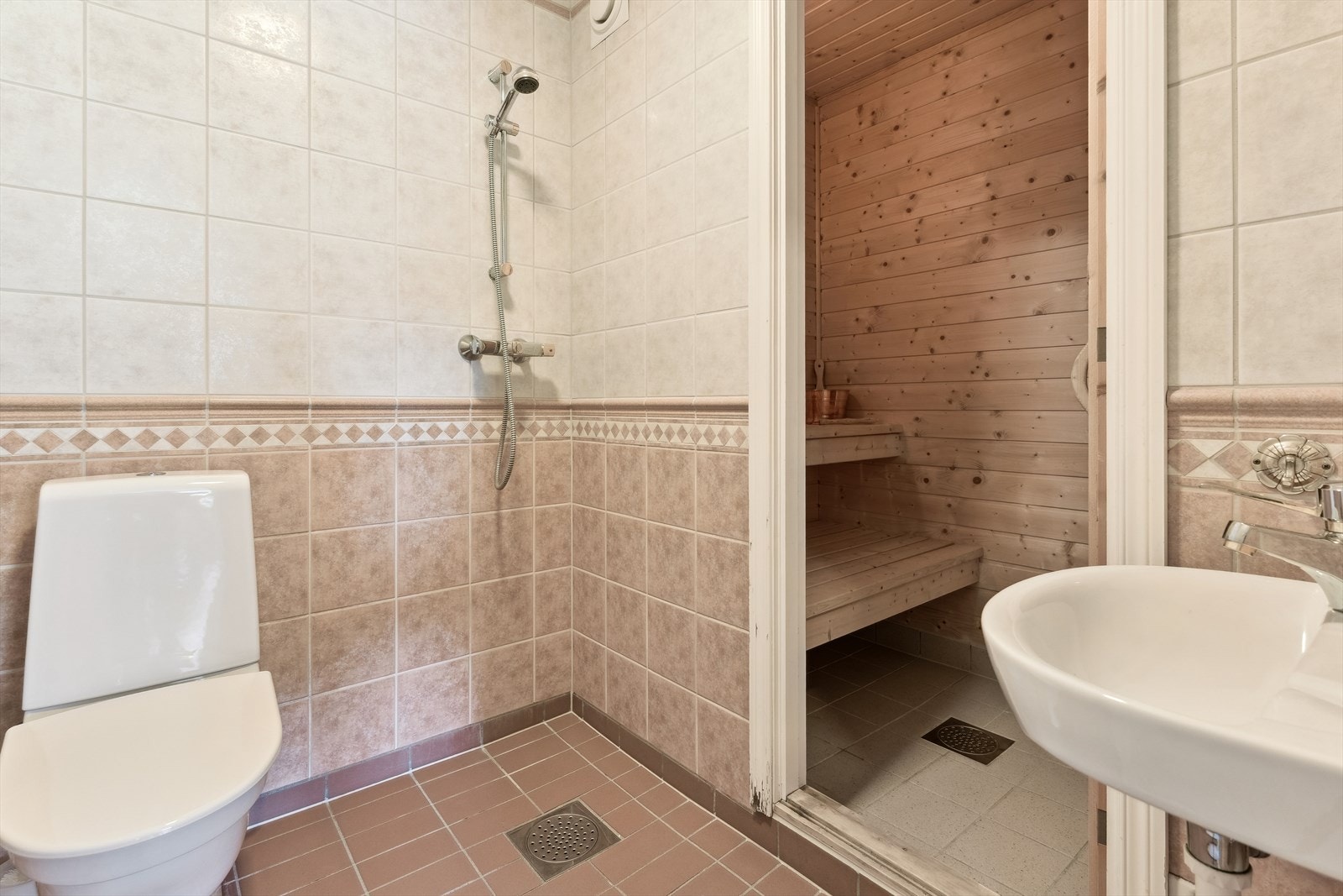 baderom med flis på golv og vegg. Badstu har du tilgang til frå badet. Galleribilde