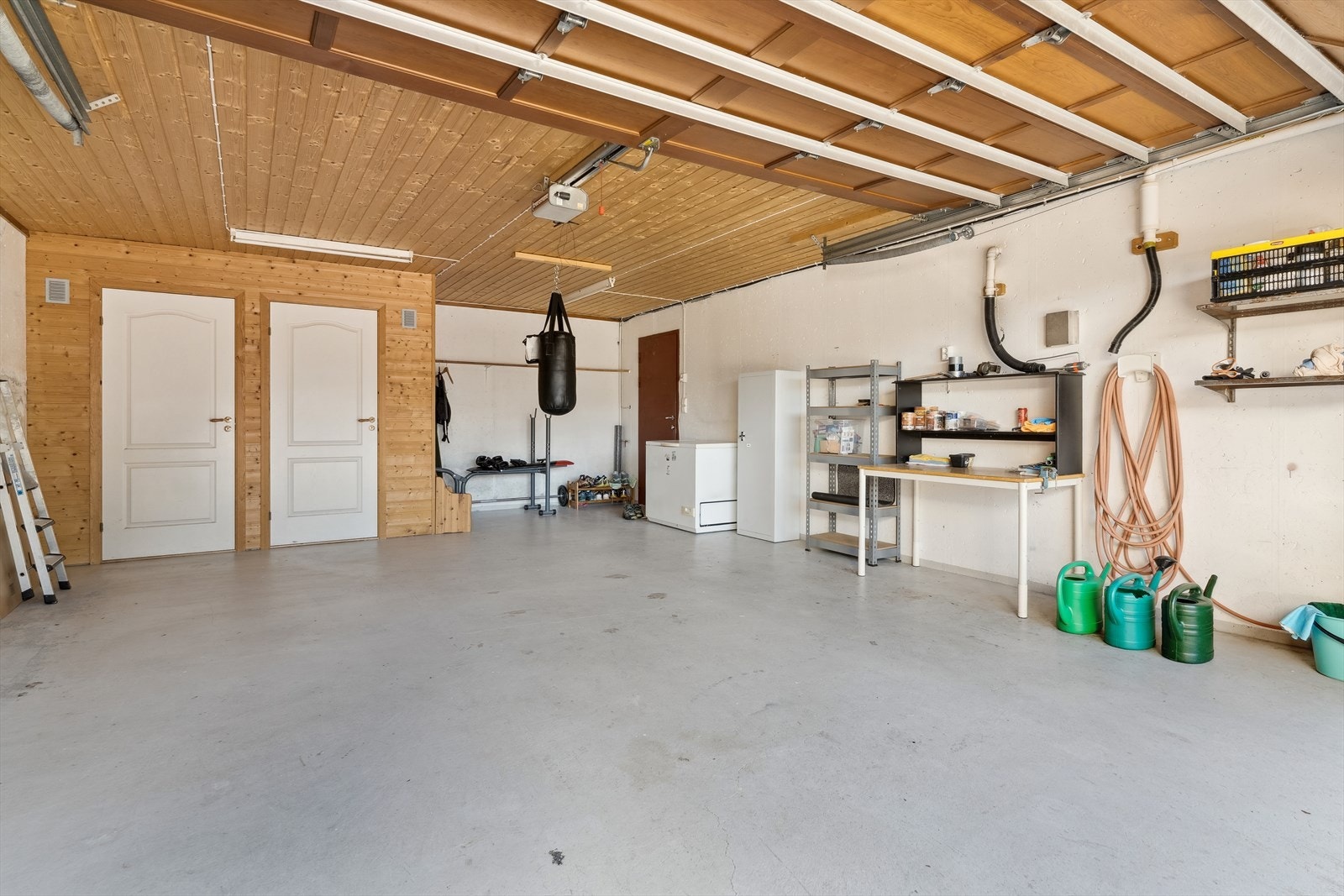 Meget romsleg plass i to garasjar. Her frå garasje tilknytta husvære via bod/vaskerom i underetasje. To boder ser du i bilde rett fram.
Det er også satt opp garasje på ca 50m² på tunet, med terrasse på tak. Galleribilde