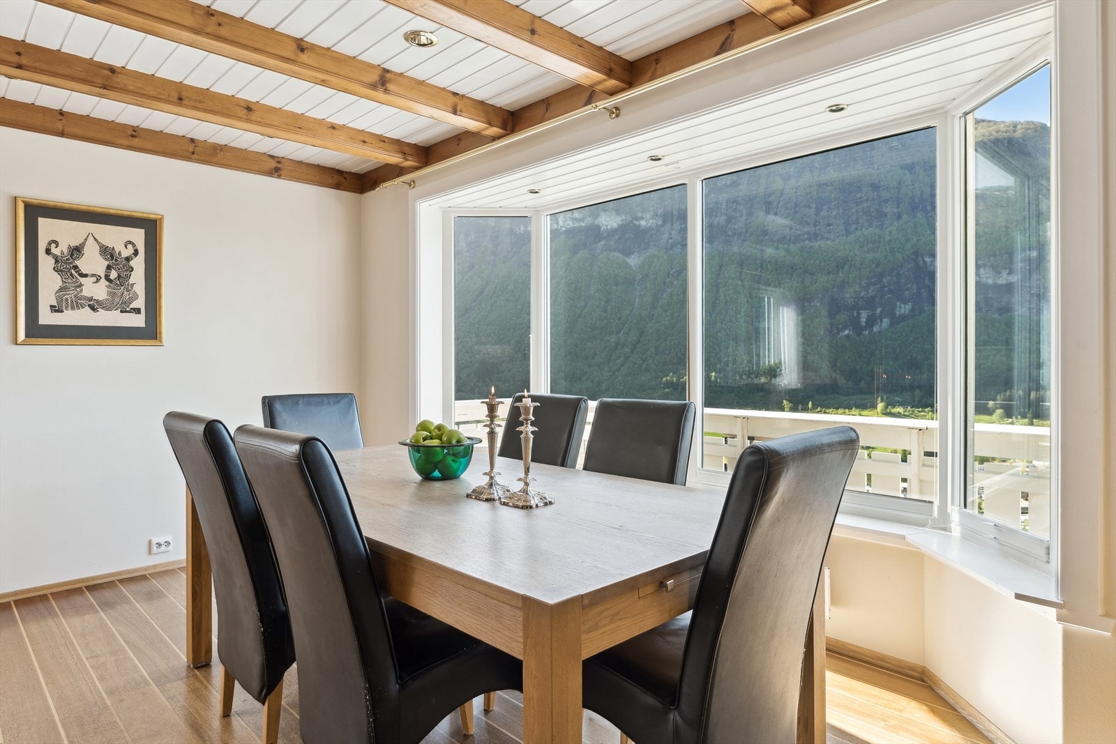 Frå stova kjem du inn til eit romsleg kjøkken som også har store vindaugsflater mot nydelig utsikt Galleribilde