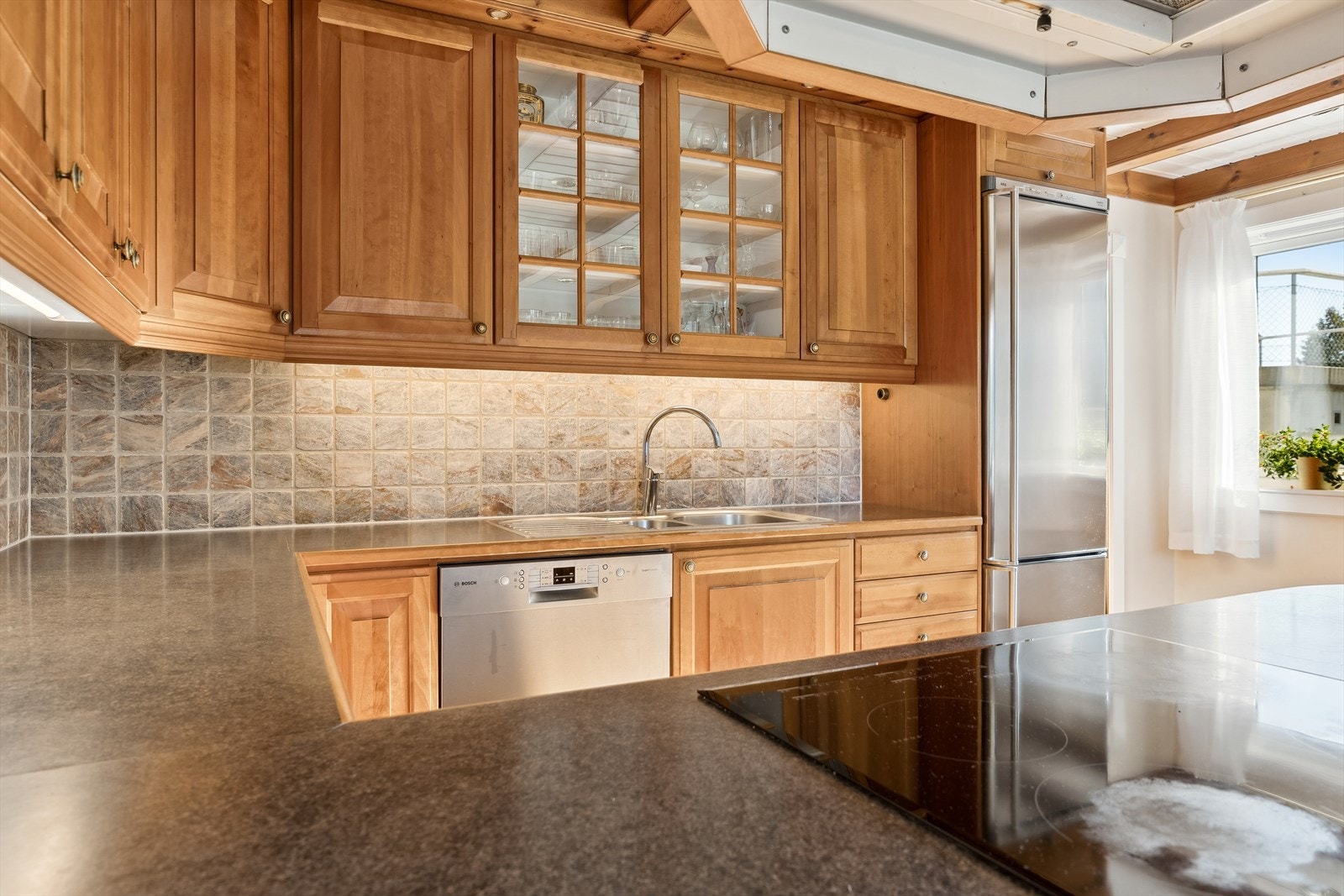 Kjøkken med haløy mot resten av kjøkkenet skapar ei sosial og fin sone for familie og venner. Galleribilde