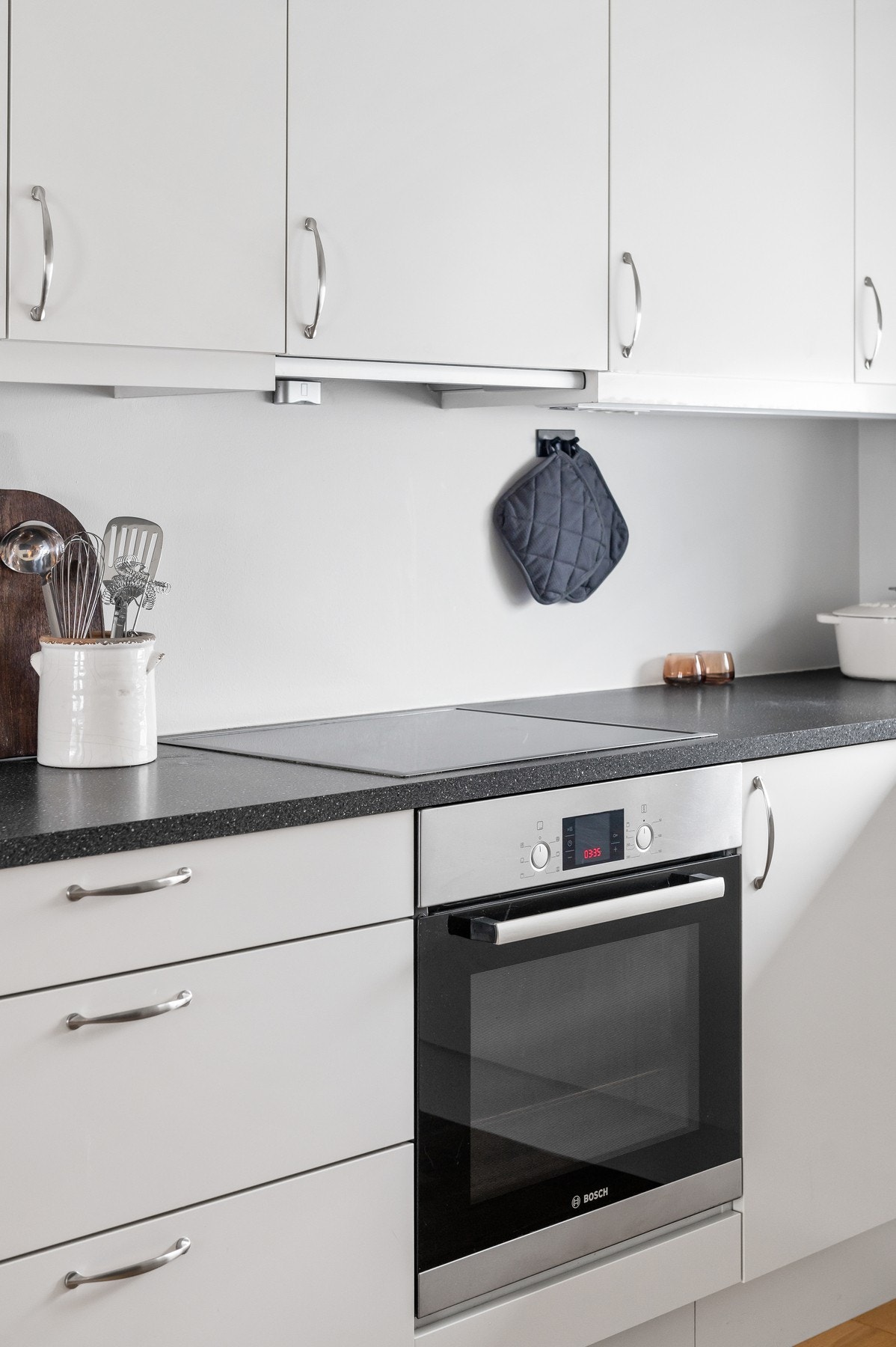 Innredning med stekovn, platetopp og mekanisk avtrekksvifte over stekesonen. Galleribilde