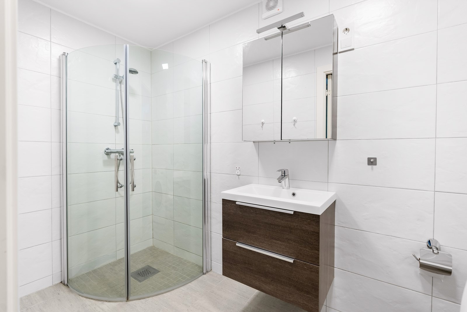 Det er gulvvarme, og rommet er videre utstyrt med innfellbare dusjdører, mekanisk avtrekk, opplegg for vaskemaskin, stoppekran, servantskap og veggmontert wc. Galleribilde