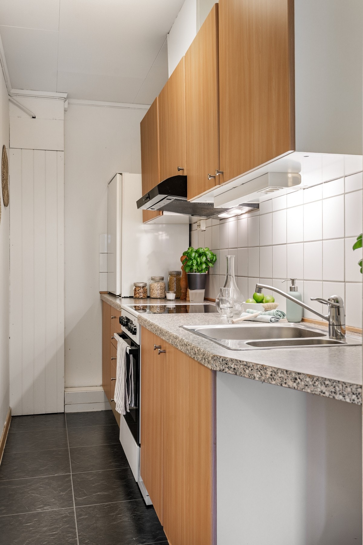 Kjøkkenet er innredet med benkeplate, over- og underskap med slette fronter. Galleribilde