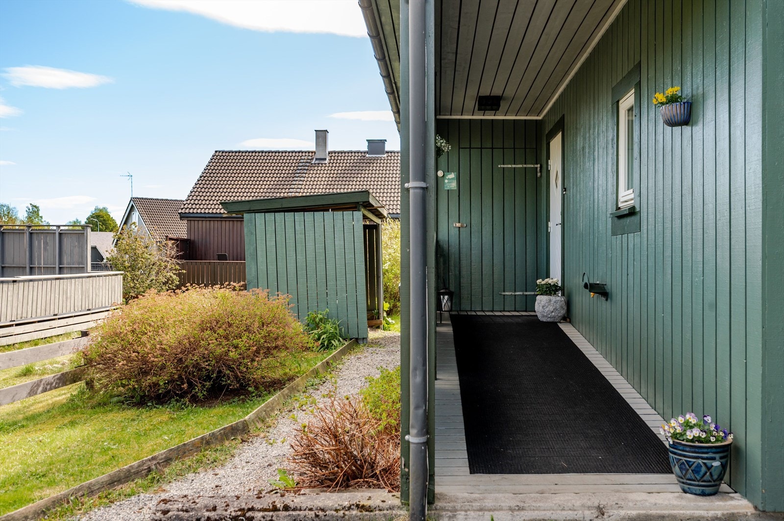 Du ønskes velkommen inn via et hyggelig overbygget inngangsparti. Til venstre for inngangsdøren er det adkomst til en praktisk utvendig bod på 5m². Eiendommen er også bebygd med overbygget uthus for lagring på ca. 4m² (ikke måleverdig areal). Galleribilde