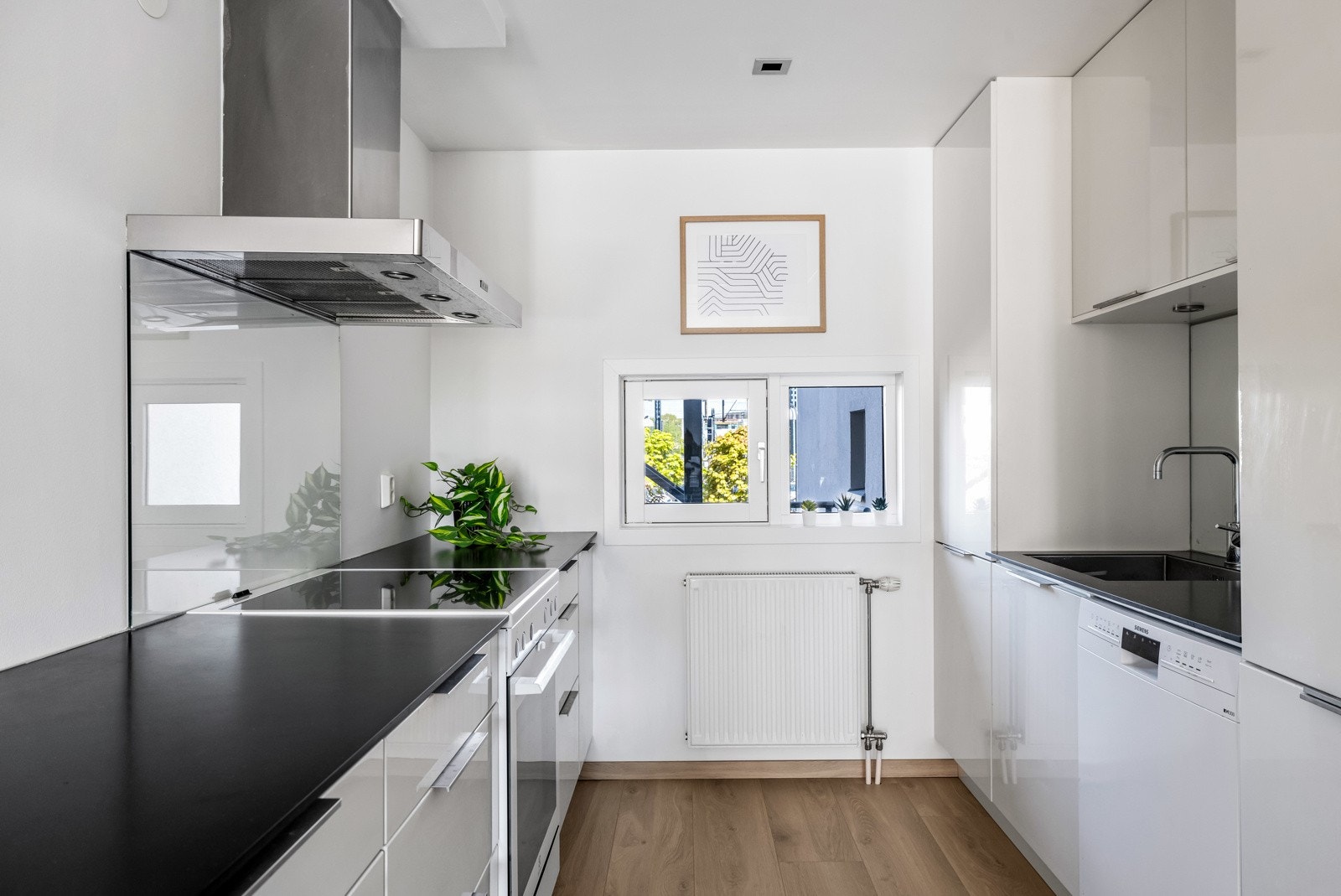 Kjøkkenet ligger tilbaketrukket innerst i allrommet, og har praktisk innredning på begge sider. Legg merke til det lille vinduet på ytterveggen som gir naturlig lysinnslipp. Galleribilde