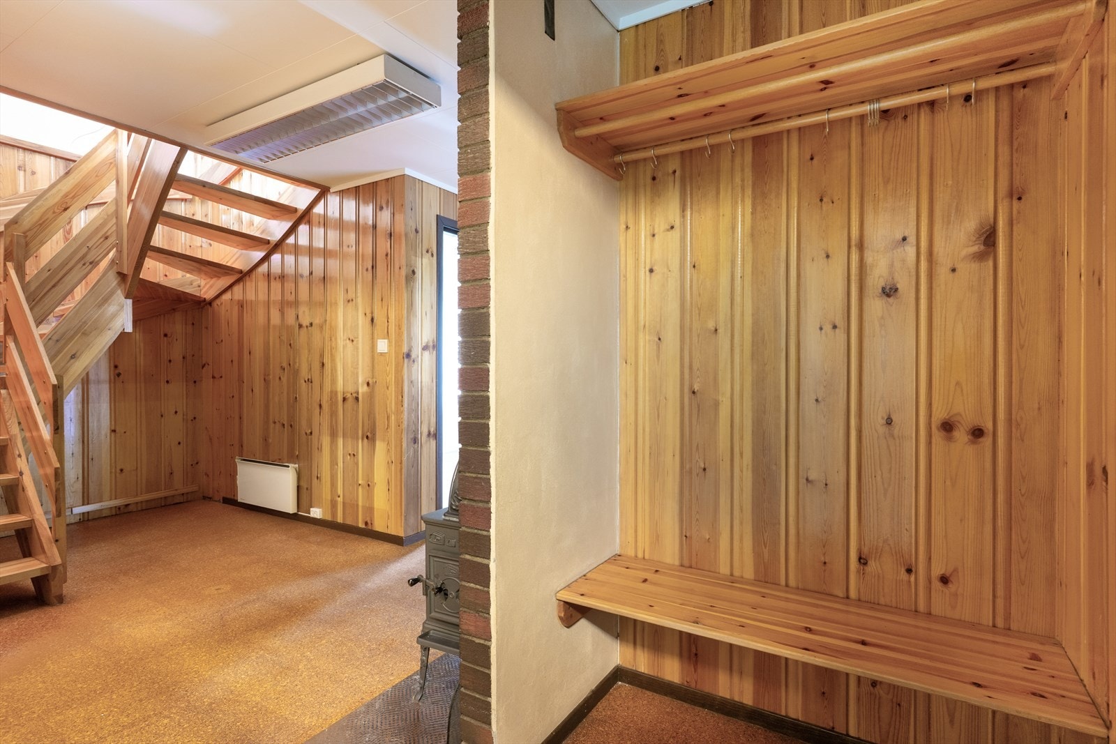 Gulvflater har korkbelegg, panel og malte plater på vegger og tak-ess i himling. Boligens sikringsskap med automatsikringer er plassert i entré. Galleribilde