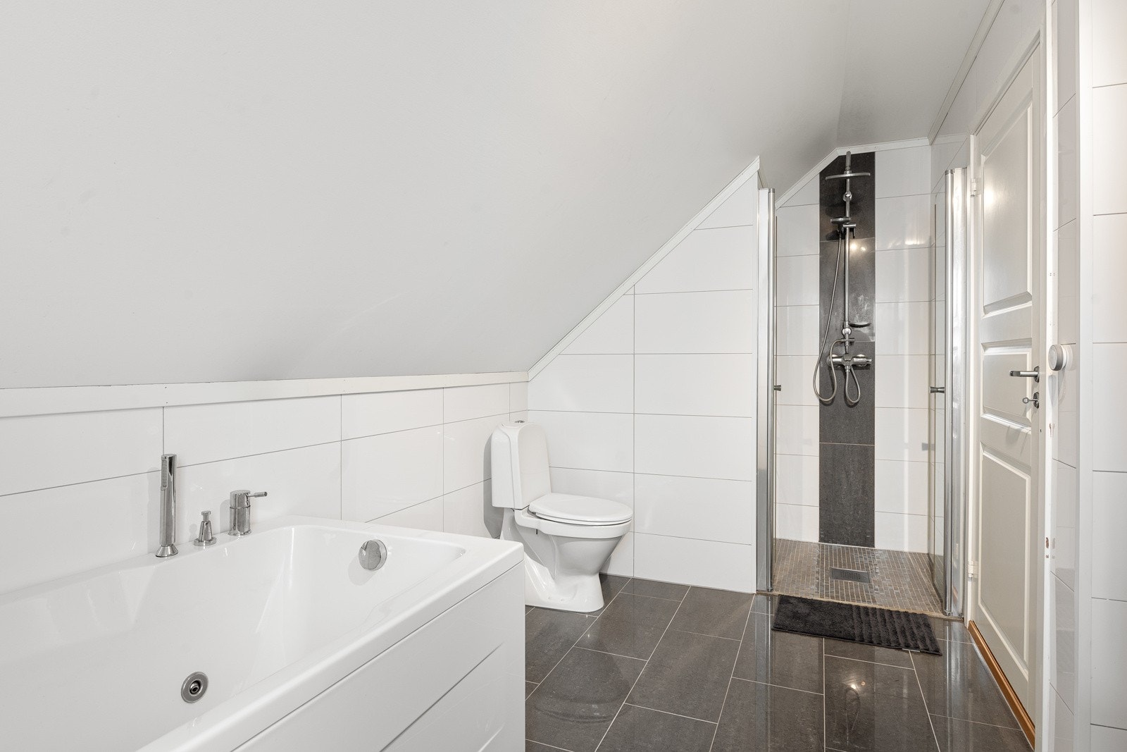 Bad 2. etasje med badekar, dusjnisje, WC og pen innredning med servant og speil. Galleribilde