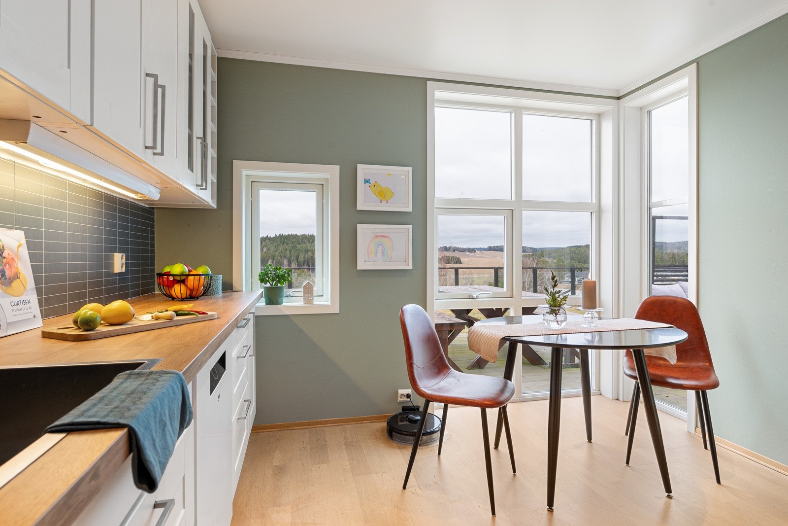 Store vindusflater gjør kjøkkenet lyst og trivelig Galleribilde