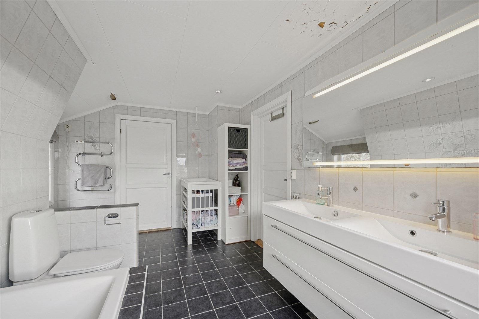 Speil og belysning over servant. Dusj i badekar, wc og opplegg for vaskemaskin. Galleribilde