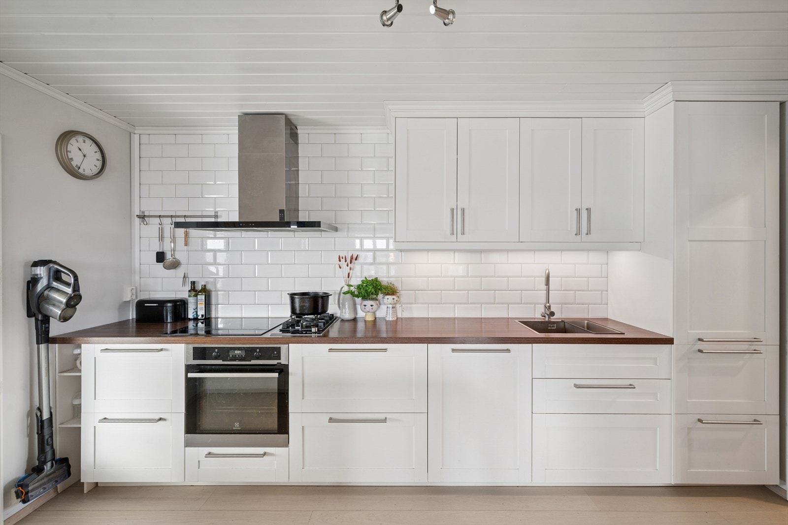 Tiltalende og velutstyrt kjøkken, innredning med profilerte fronter. Belysning under overskap. Fliser på vegg over benkeskap. Laminat benkeplate med nedfelt kum i rustfritt stål. Galleribilde