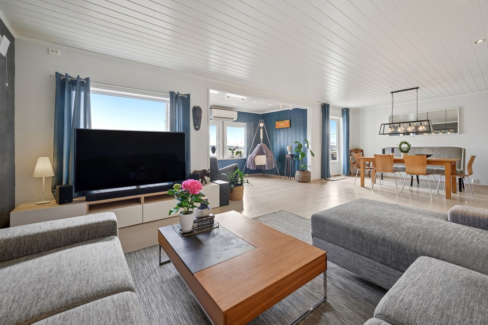 Lys og romslig stue med store vindusflater som lar dagslyset flyte fritt. Galleribilde