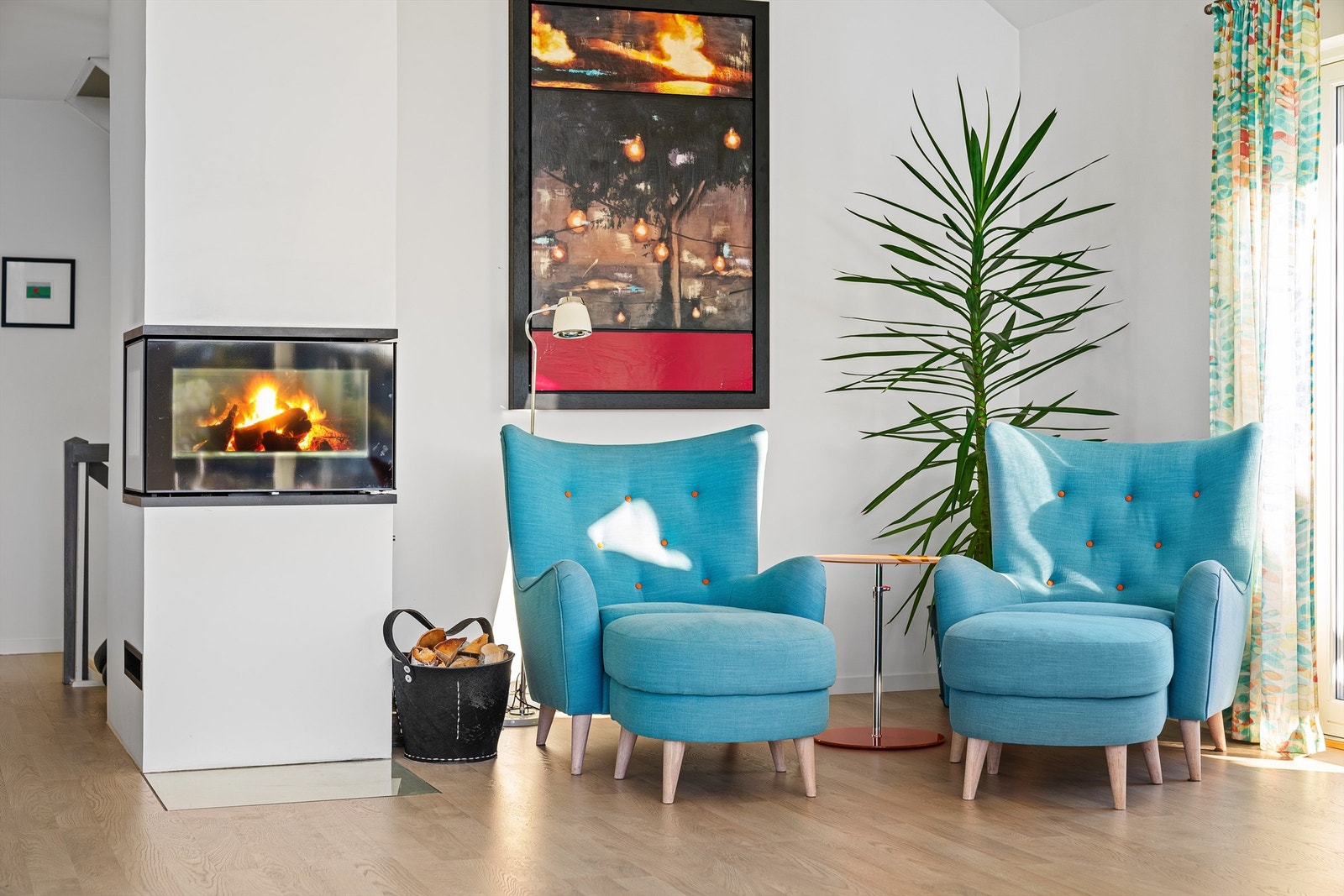 Lekker rentbrennende peis i stuen med plass til en lesekrok med godstoler Galleribilde