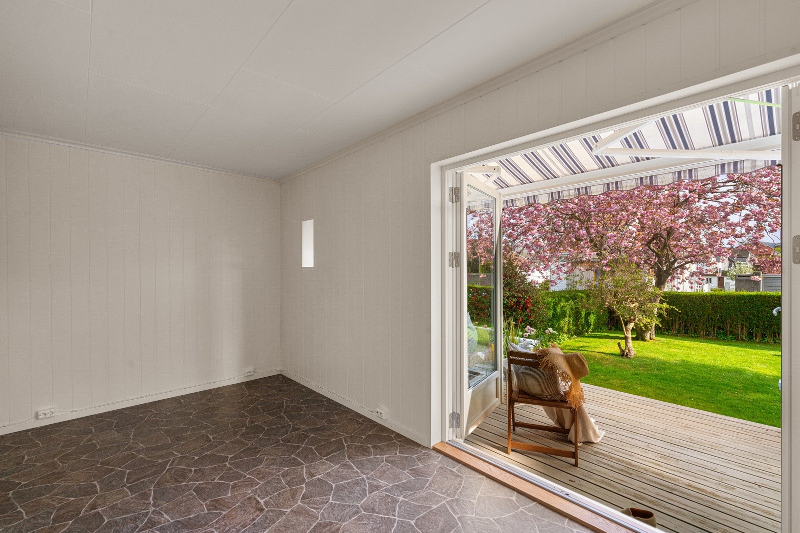 Innerst i stuen er det en ekstra stue/spisestue og herfra har man utgang til den frodige og pent opparbeidede hagen. Galleribilde