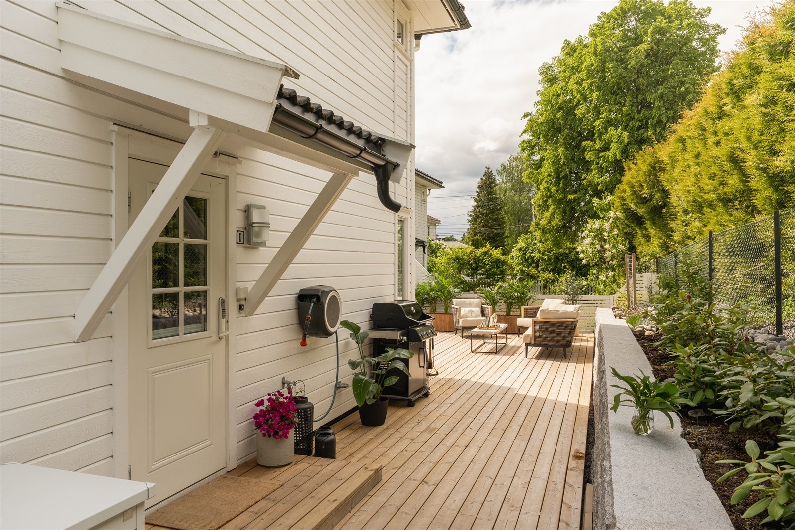 Velkommen inn. Tomten er pent opparbeidet med granittstein, blomsterbed og inngjerding Galleribilde