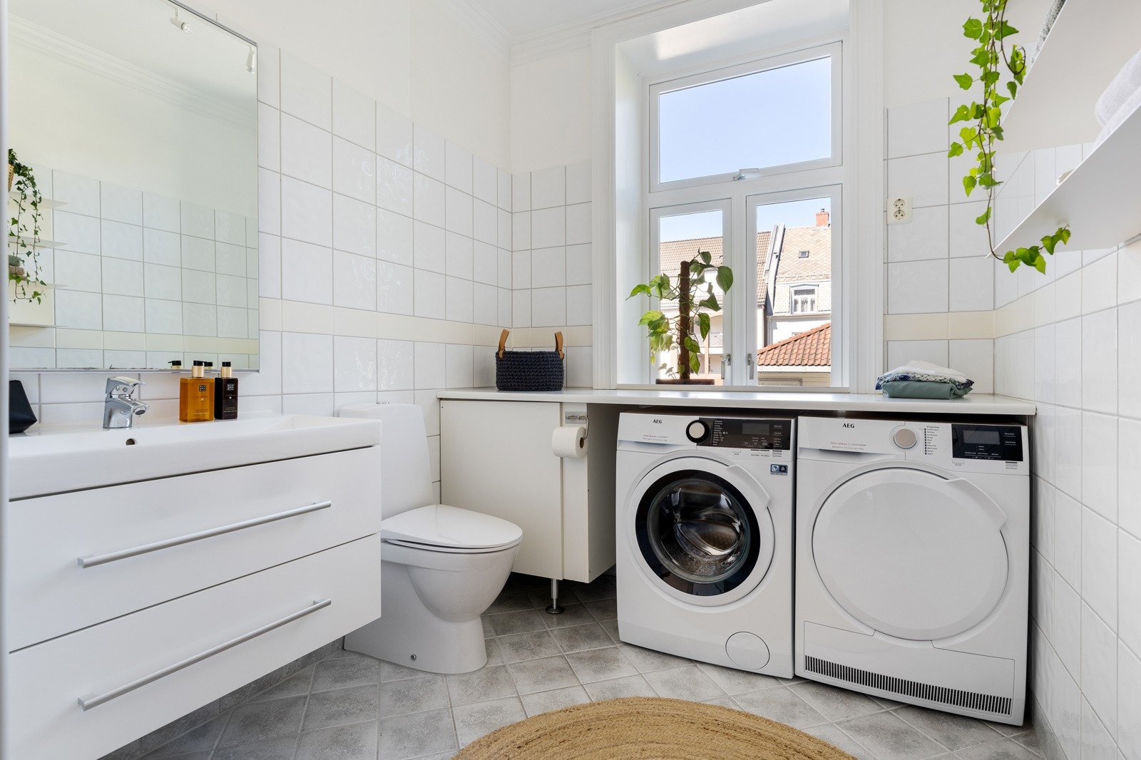 Det 7,5 kvm store badet er flislagt med behagelig gulvvarme. Vaskemaskin og tørketrommel er godt integrert i rommet med overliggende benkeplate. Galleribilde