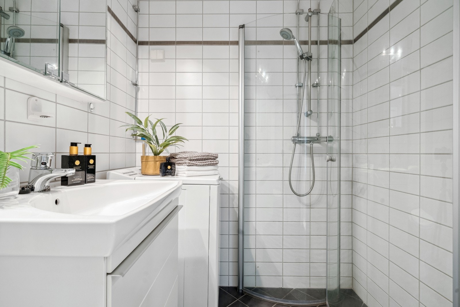 Toalett, servant med moderne innredning, dusjvegger. Opplegg for oppvaskmaskin. Galleribilde