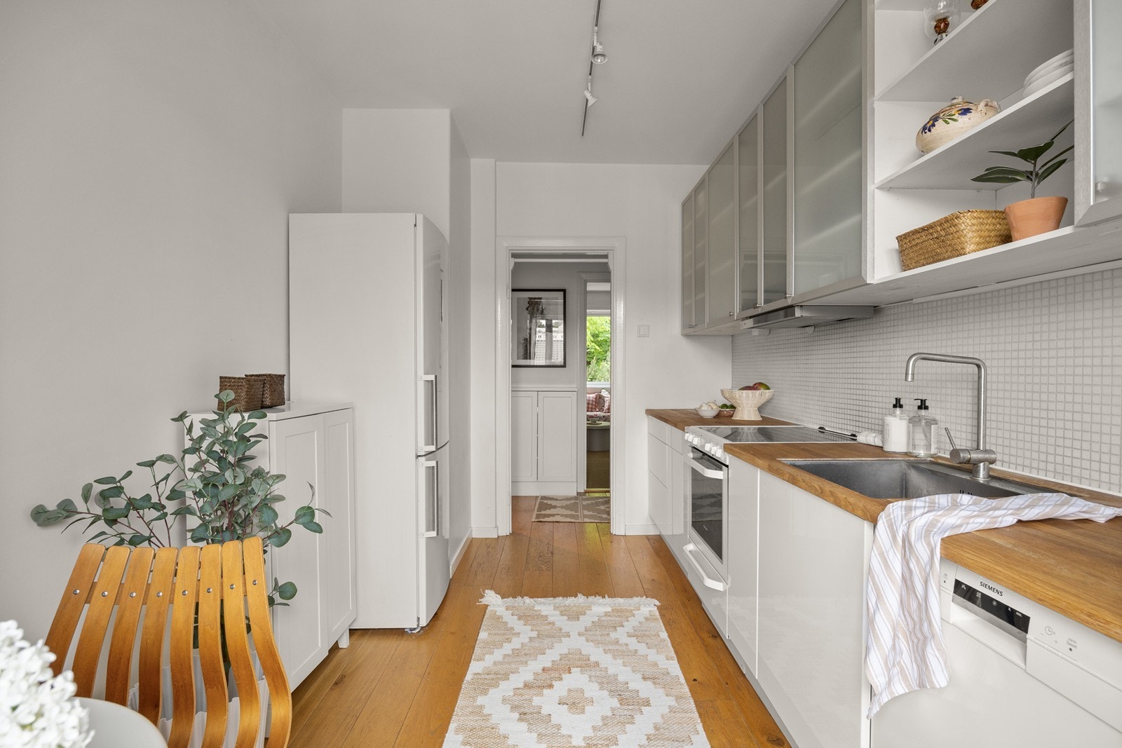 IKEA-kjøkken fra 2010, utstyrt med komfyr, nedfelt kum, ettgreps blandebatteri, kombi kjøl/fryseskap og oppvaskmaskin. Galleribilde