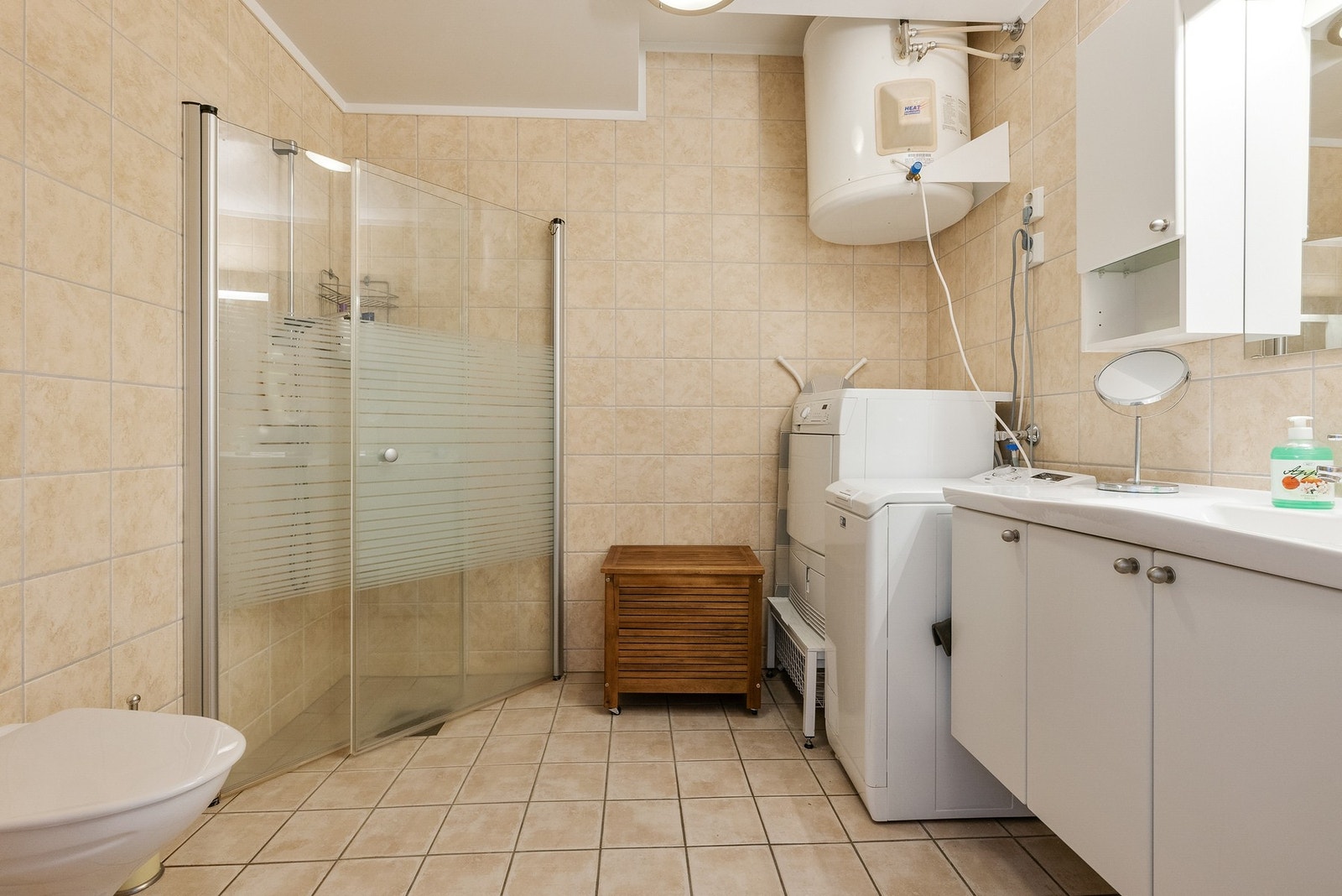 Badet har overflater med flislagte vegger og gulv Galleribilde