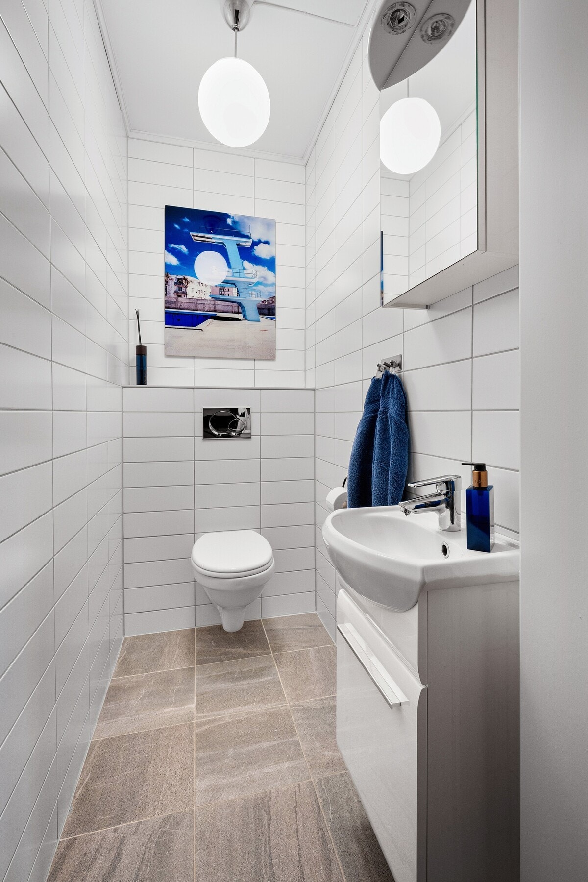 Et separat, lyst toalettrom vegg i vegg vaskerommet. Galleribilde