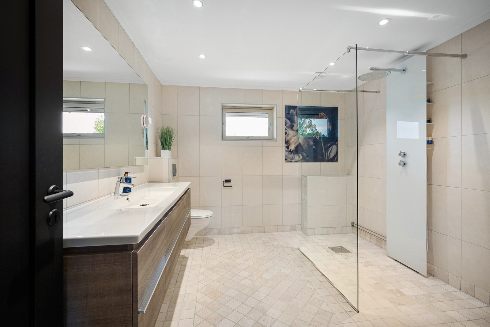 Romslig bad i 2. etasje - med stor dusjsone. Her er det tilrettelagt for komfort og avslapning. Flislagte vegger og gulv gir et stilrent uttrykk. Galleribilde