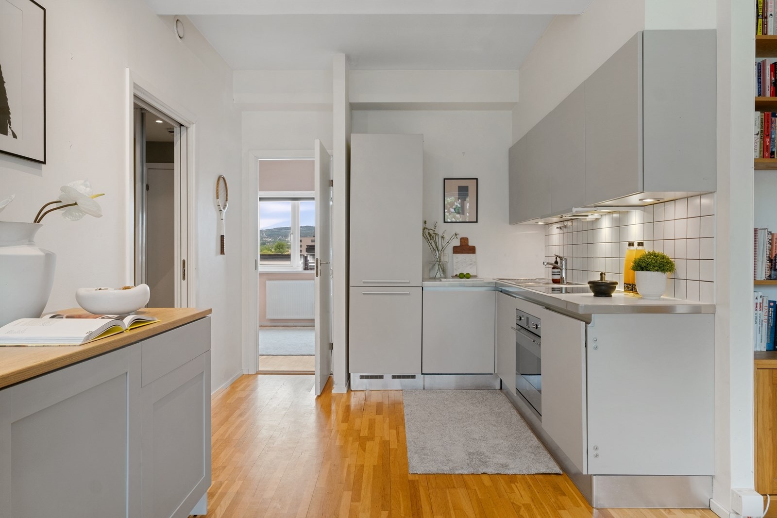 Stilig kjøkken fra Aster Cucine med glatte fronter og åpen løsning mot stuen. Galleribilde